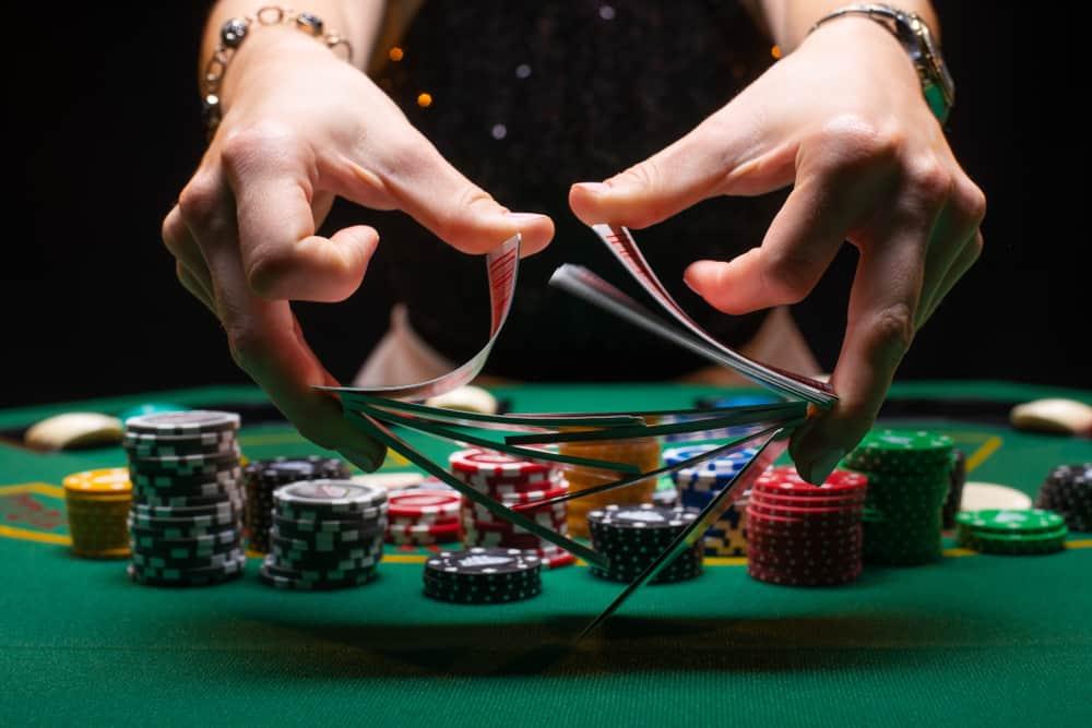 Girl dealer or croupier shuffles poker cards in a casino