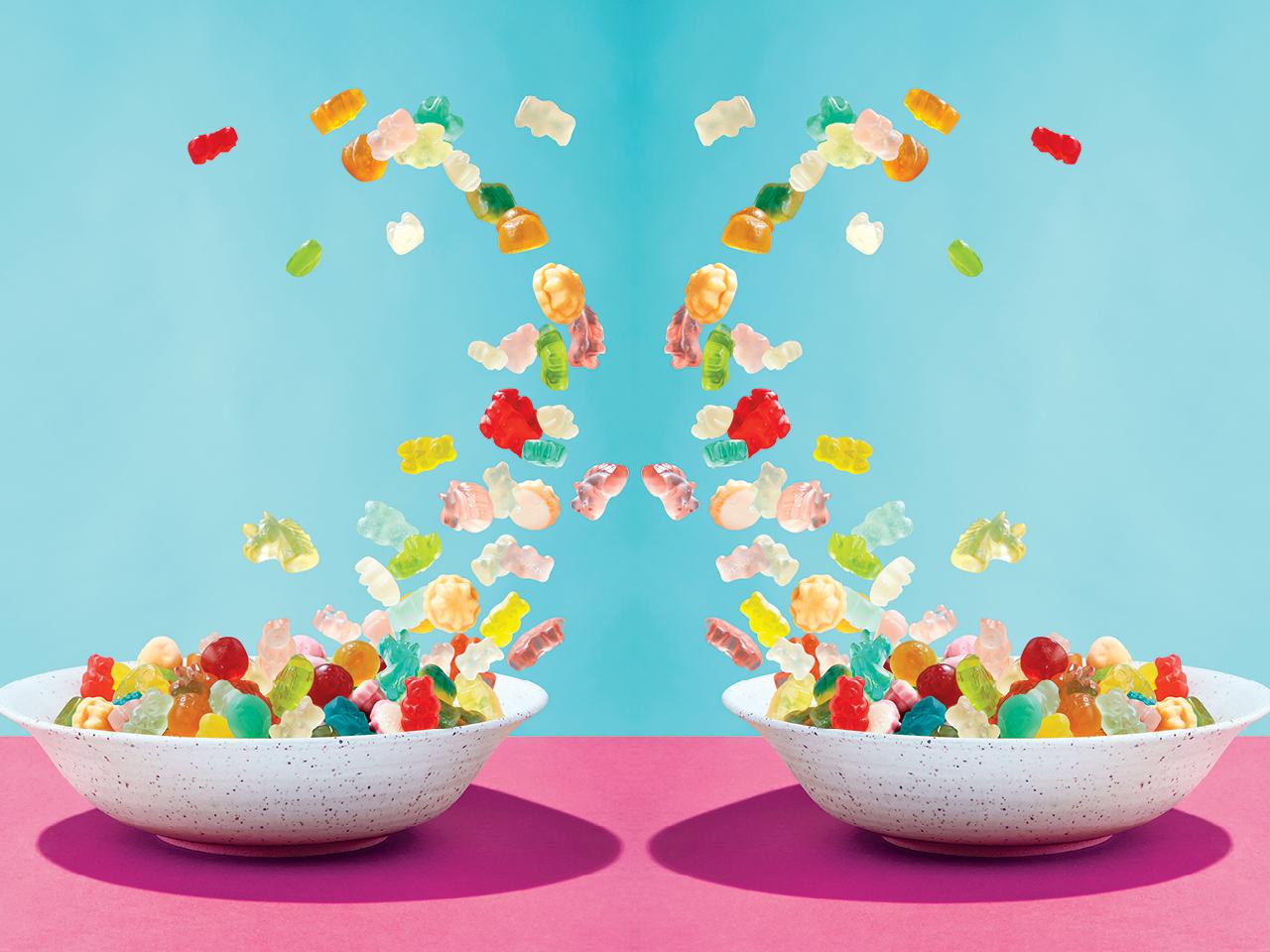 Colourful weed gummies flying out of two bowls