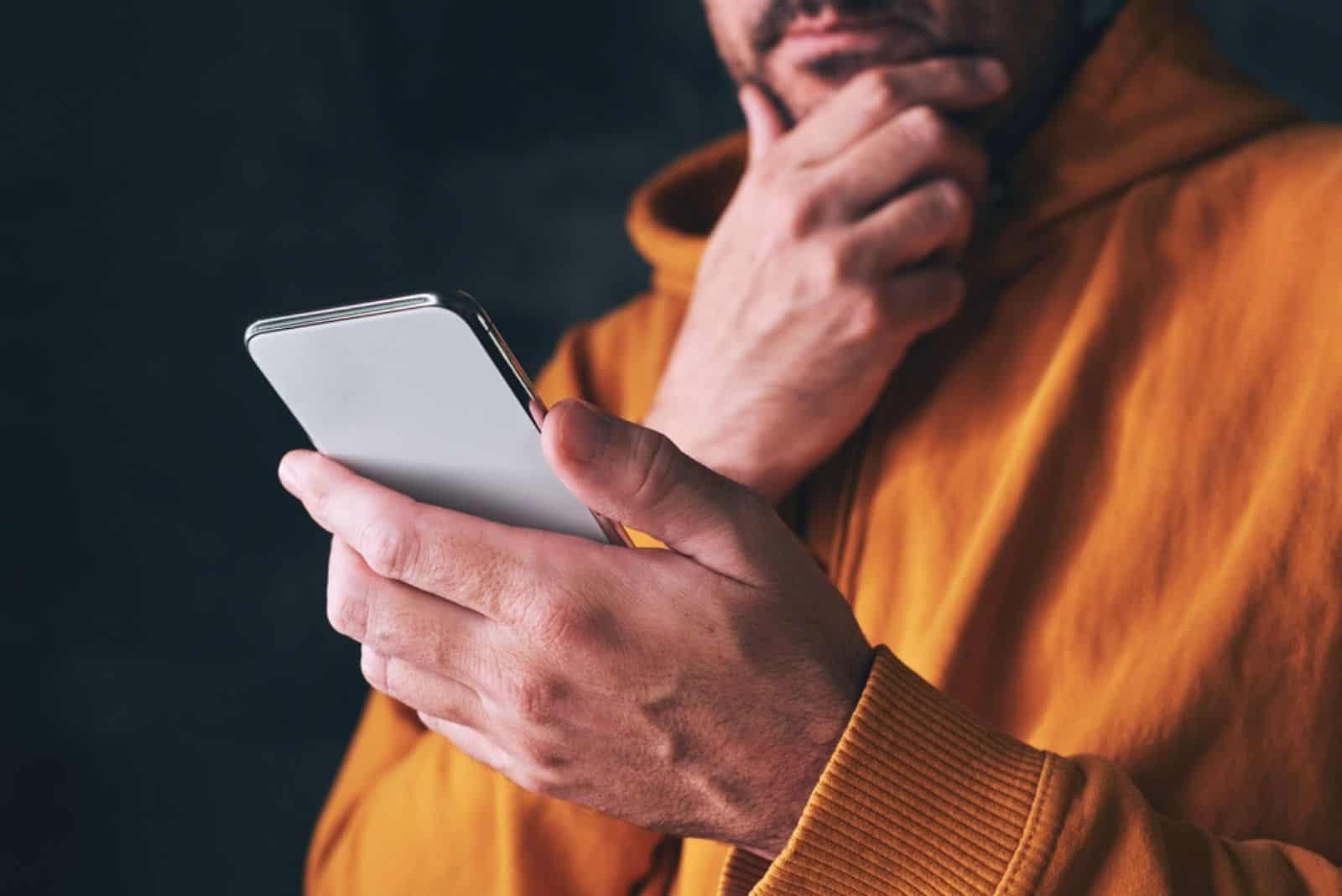 worried man holding a smartphone